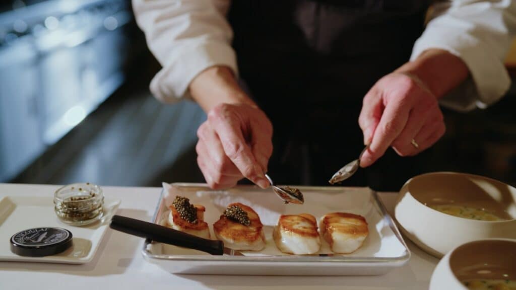 chef adding caviar to seared scallops